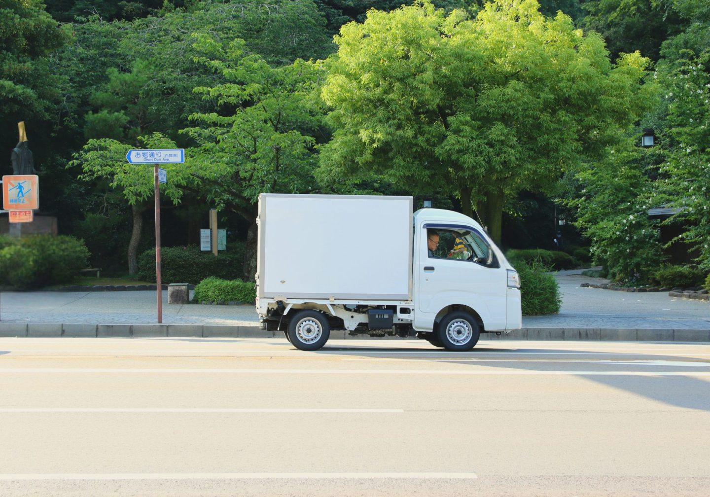 Ein weißer Lieferwagen fährt eine Straße entlang